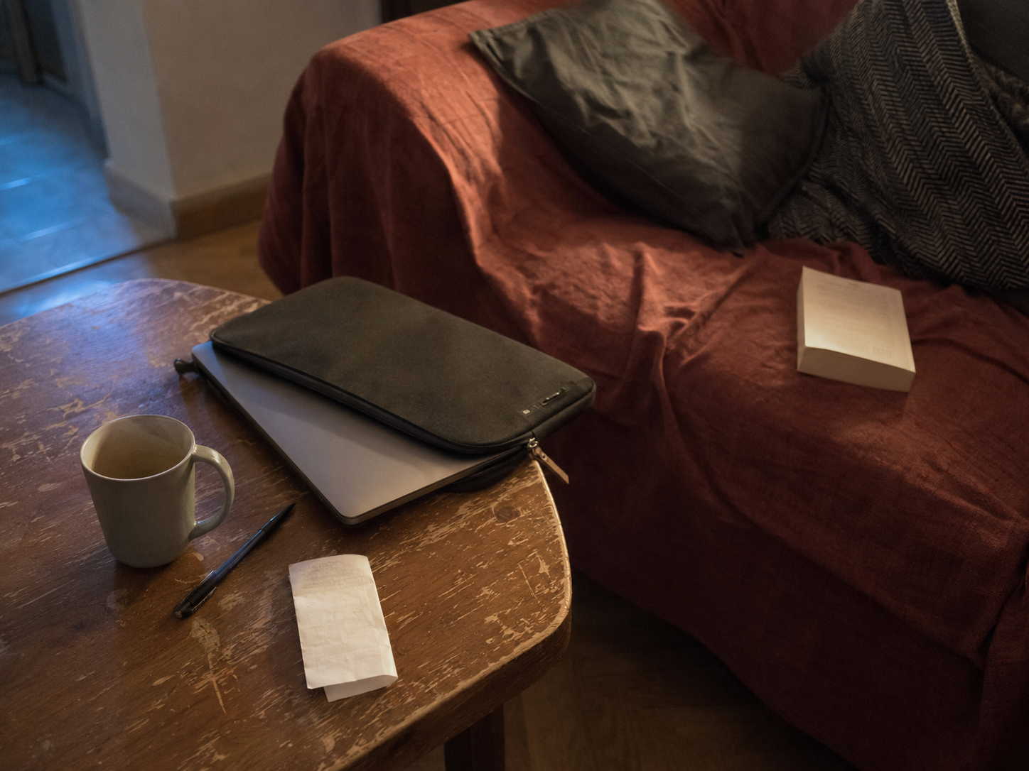 Portátil a medio guardar después de la jornada laboral junto a un libro sin abrir.